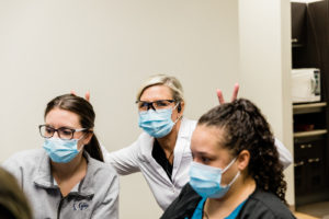 Dr. Little giving bunny ears to staff